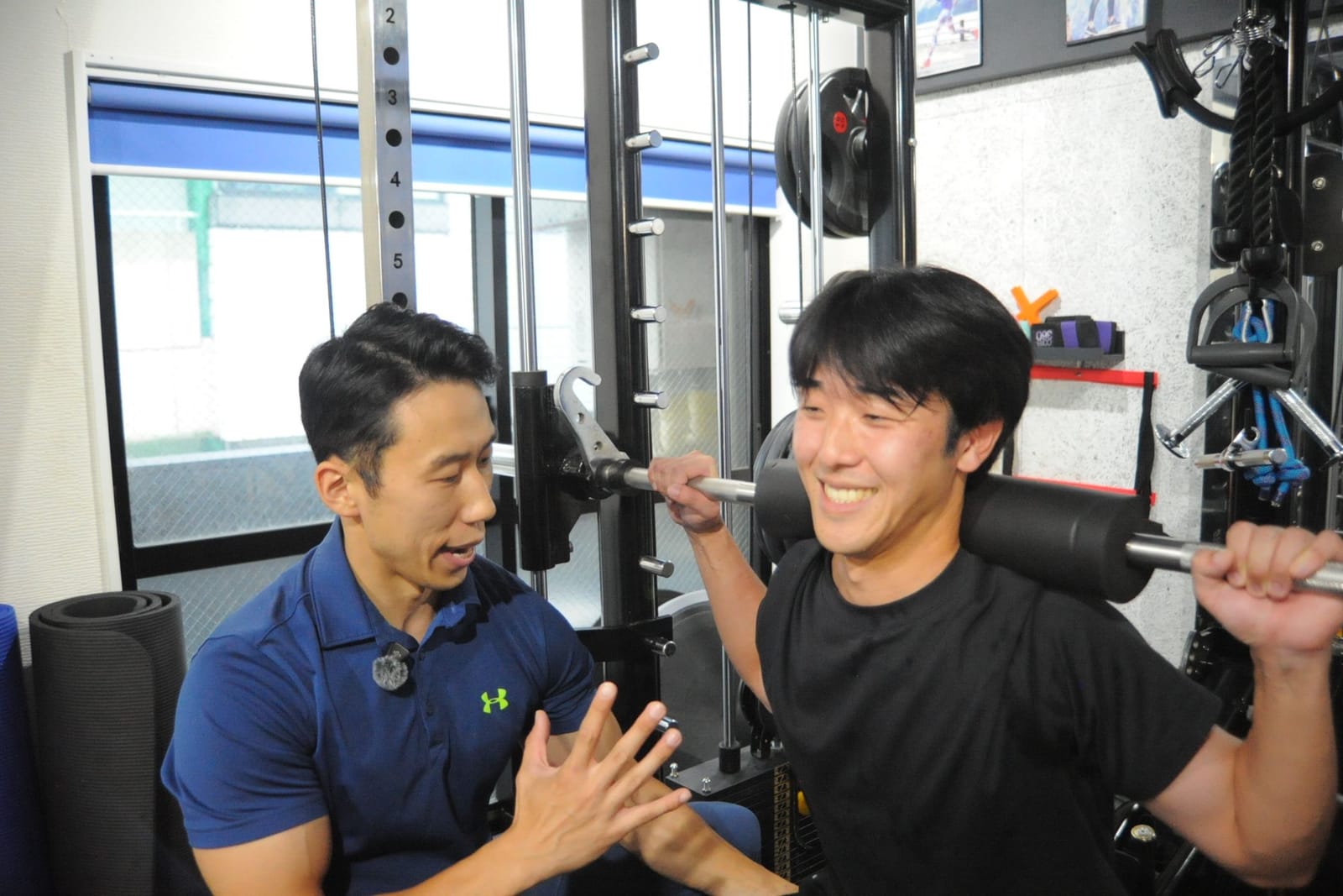 フォームを見ながら声をかけるトレーナー